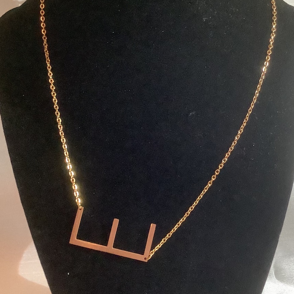 Gold toned E necklace